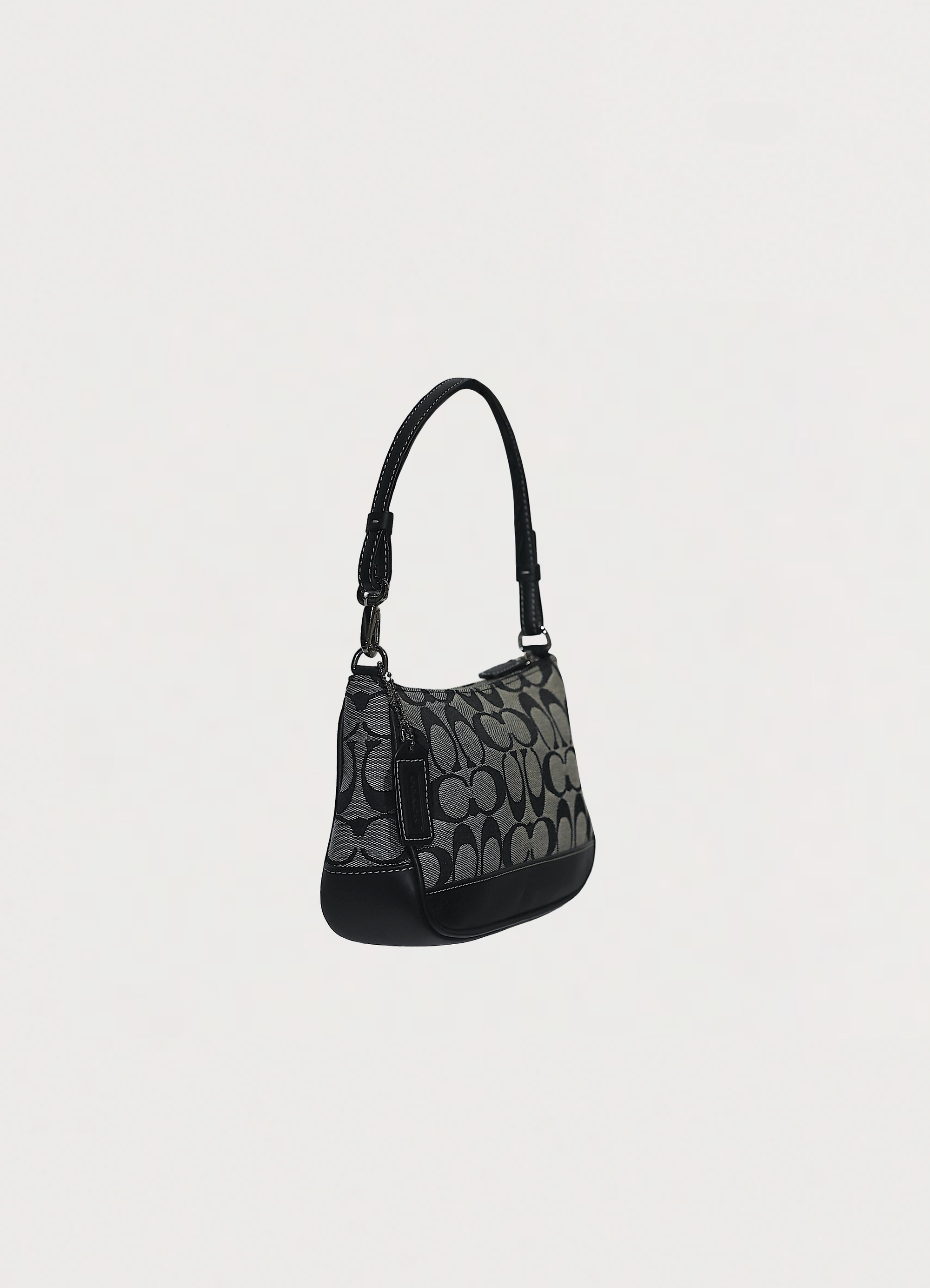 Angled side view of Coach signature pochette showing slim silhouette
