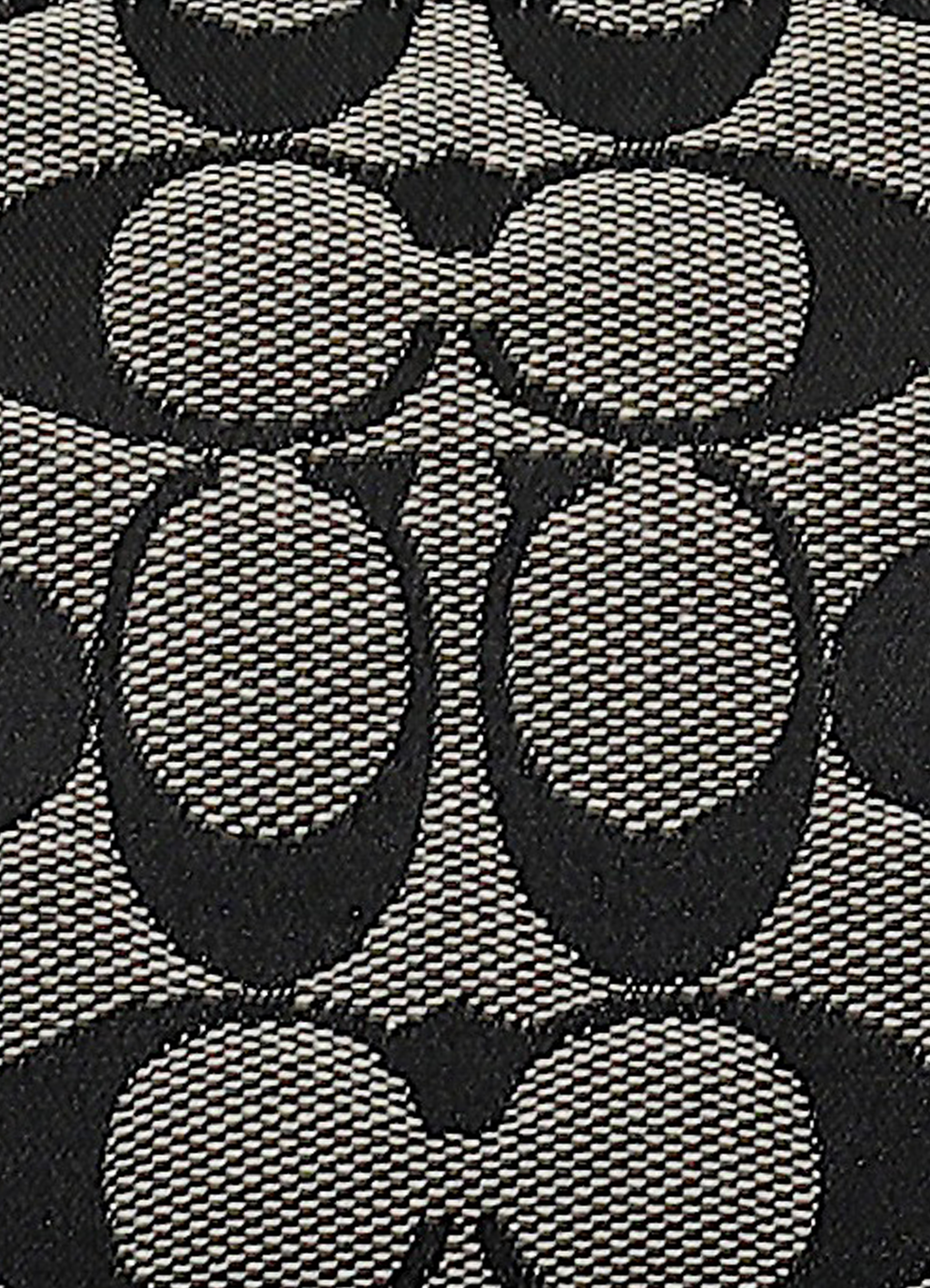 Macro shot of authentic black and grey Coach signature "C" jacquard canvas