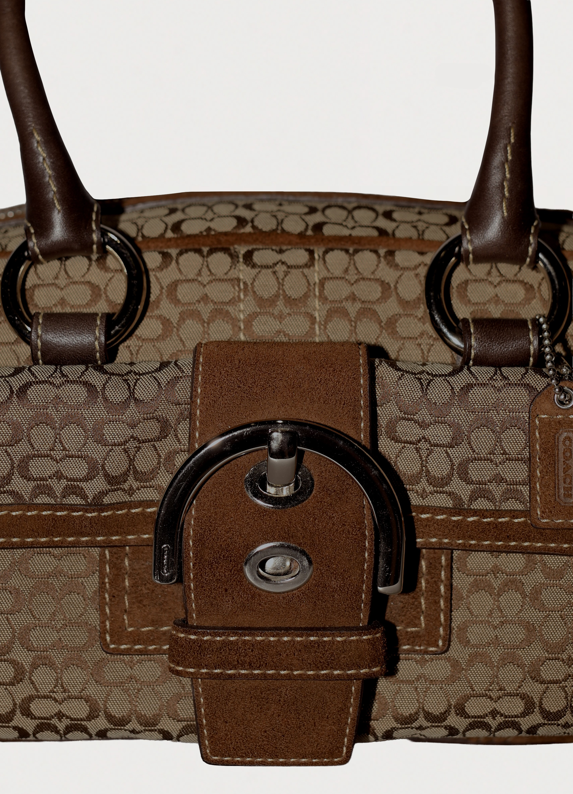 Vintage Coach Soho buckle satchel in brown signature canvas with leather trim showing close up of buckle at front