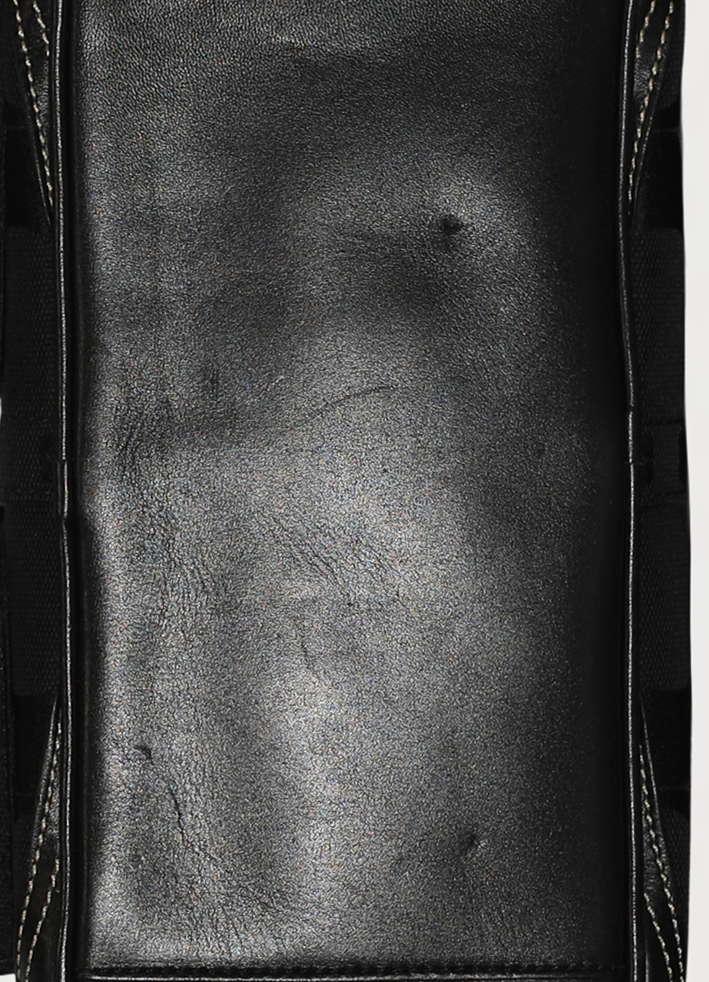 Detailed close-up of the smooth black leather base and stitching on the Coach Gallery satchel