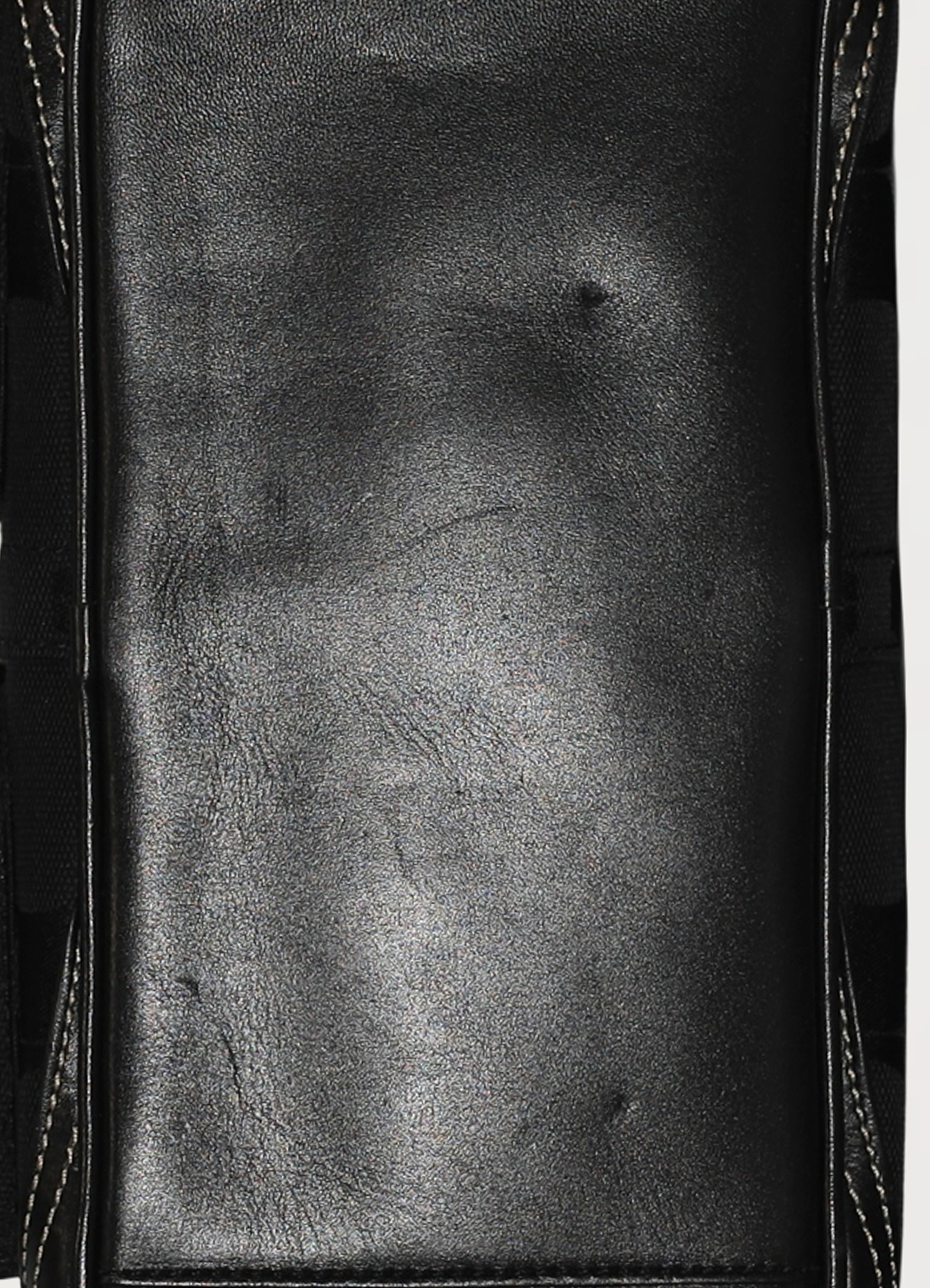 Detailed close-up of the smooth black leather base and stitching on the Coach Gallery satchel
