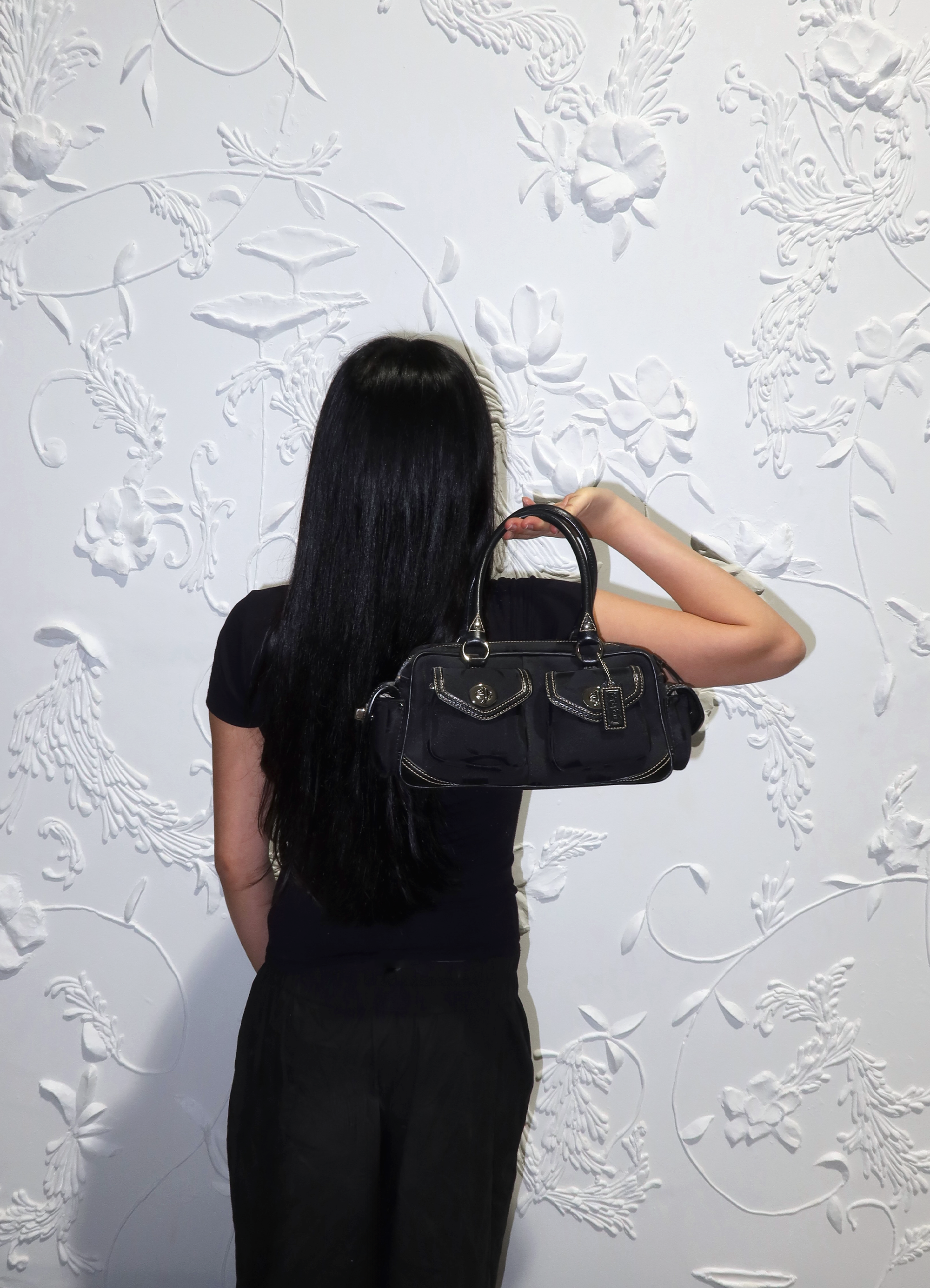 Black Coach Soho Gallery satchel held by model