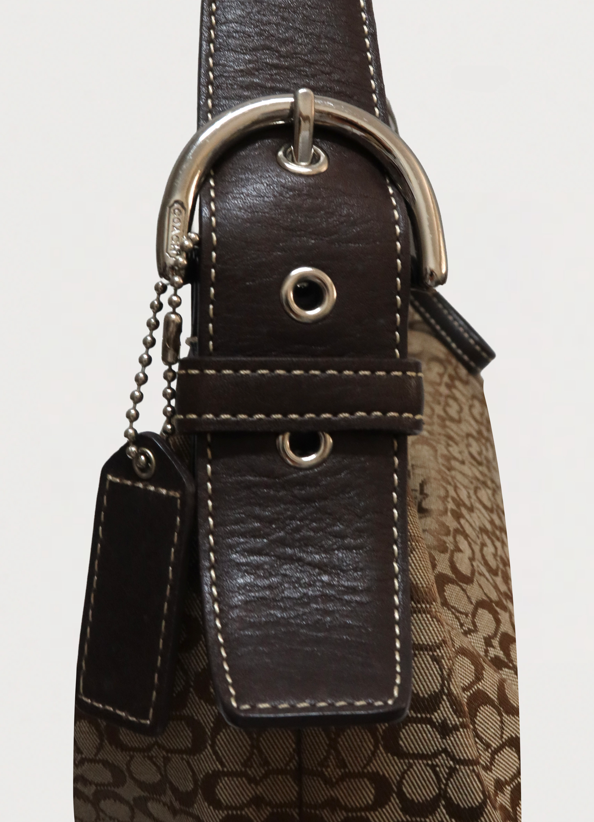 Detail of silver-tone hardware buckle and brown leather strap