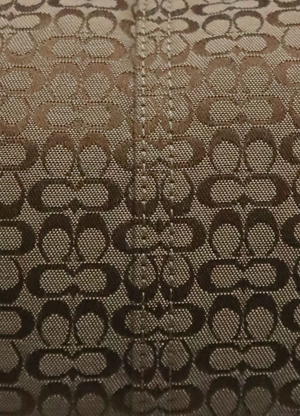 Macro shot of authentic khaki Coach signature "C" monogram jacquard pattern