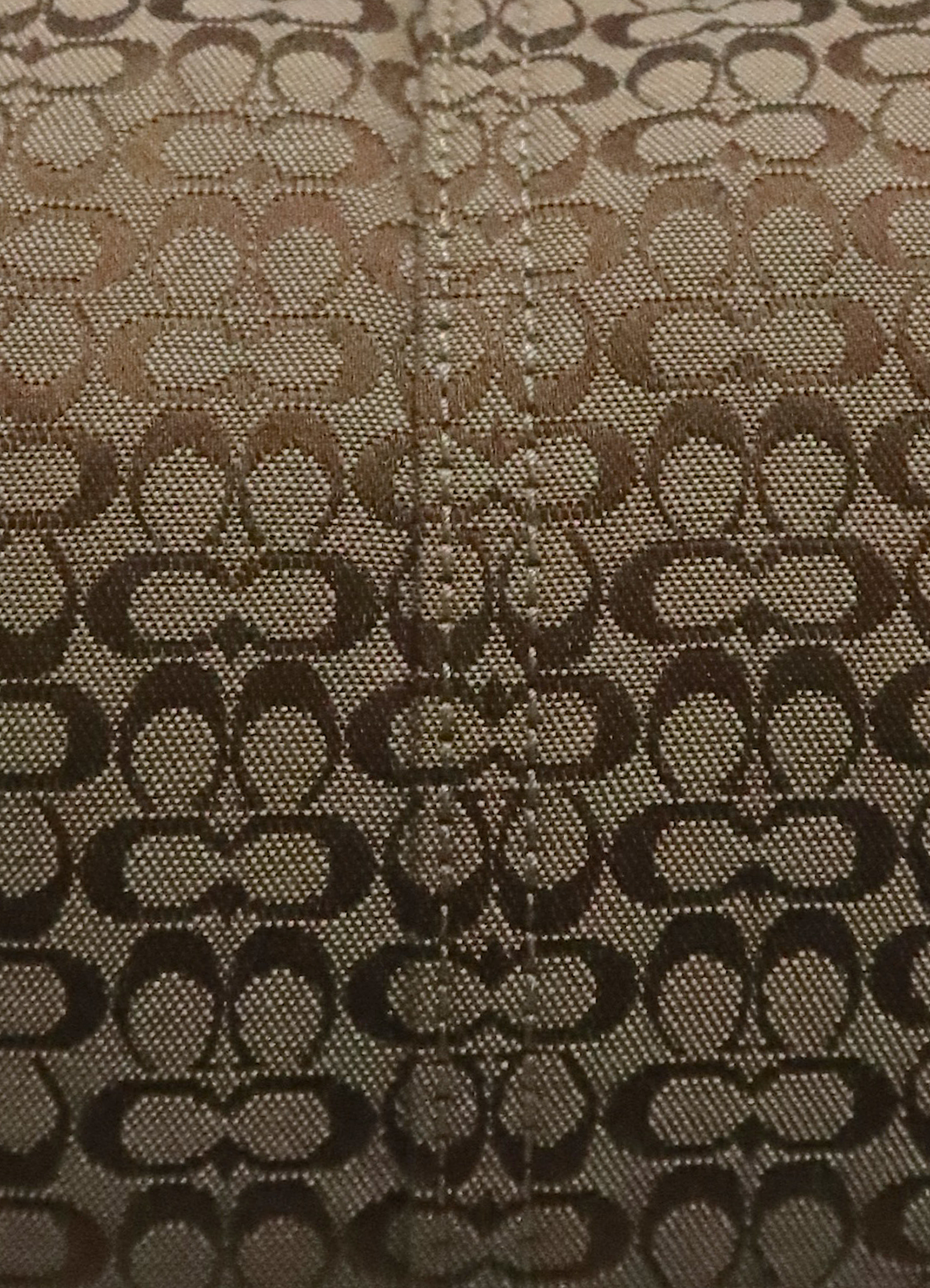 Macro shot of authentic khaki Coach signature "C" monogram jacquard pattern