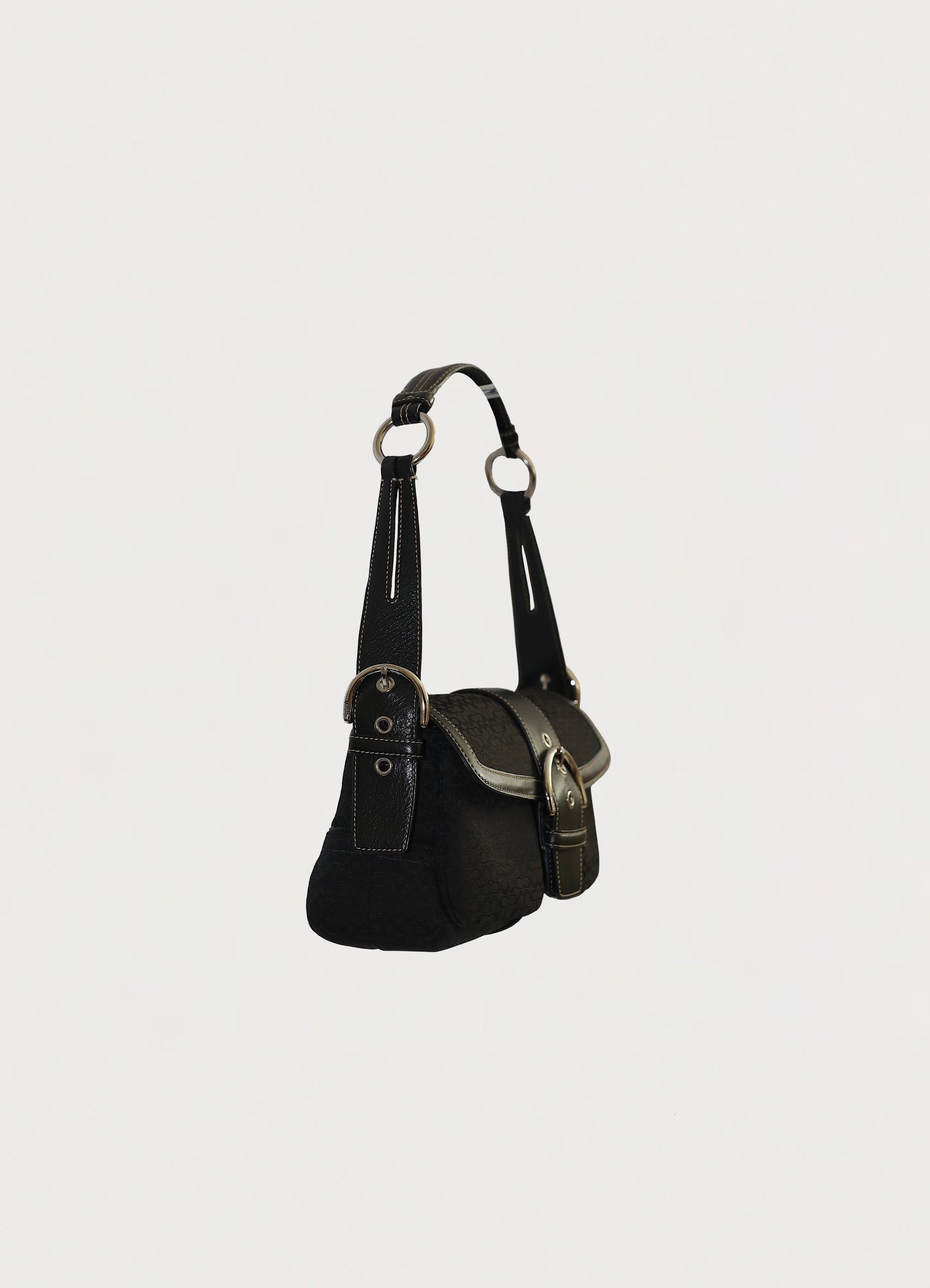 Angled side view of black Coach Soho flap bag showing bag depth