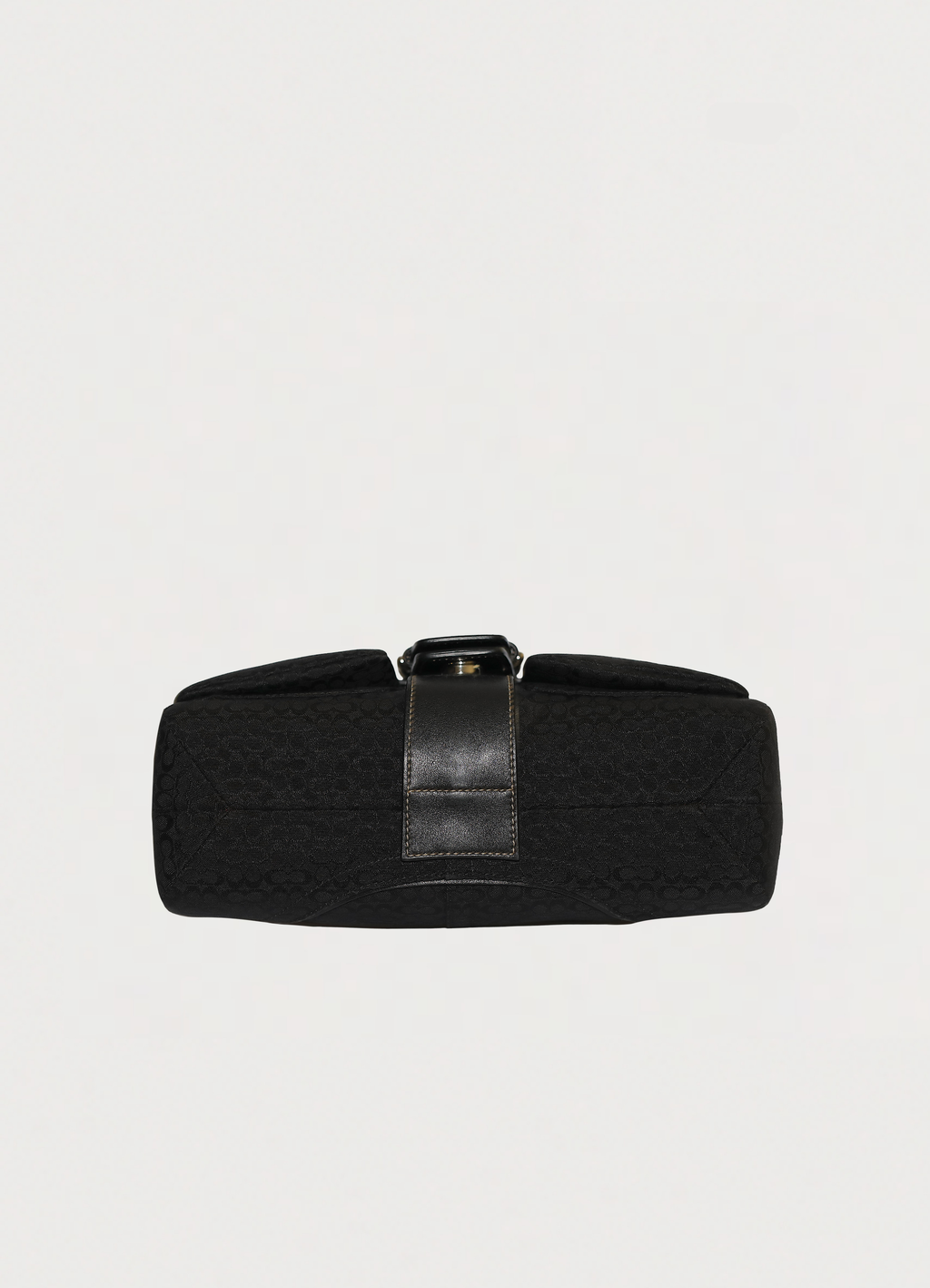 Base view of black Coach Soho flap bag showing signature canvas bottom