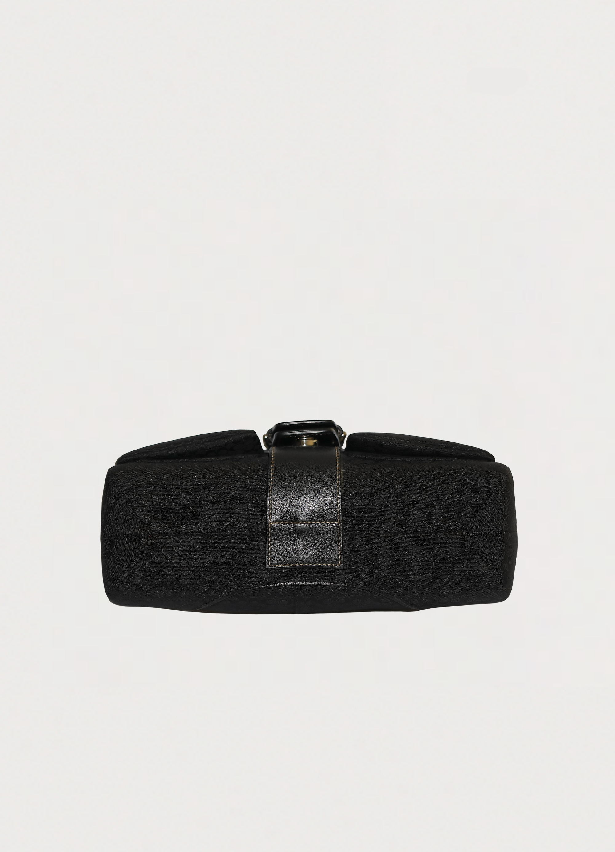 Base view of black Coach Soho flap bag showing signature canvas bottom