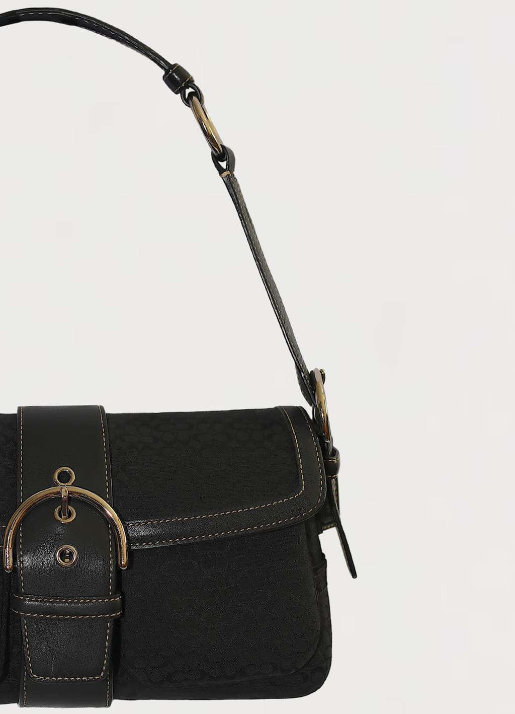Close up of the black leather buckle strap and silver-tone hardware on the flap