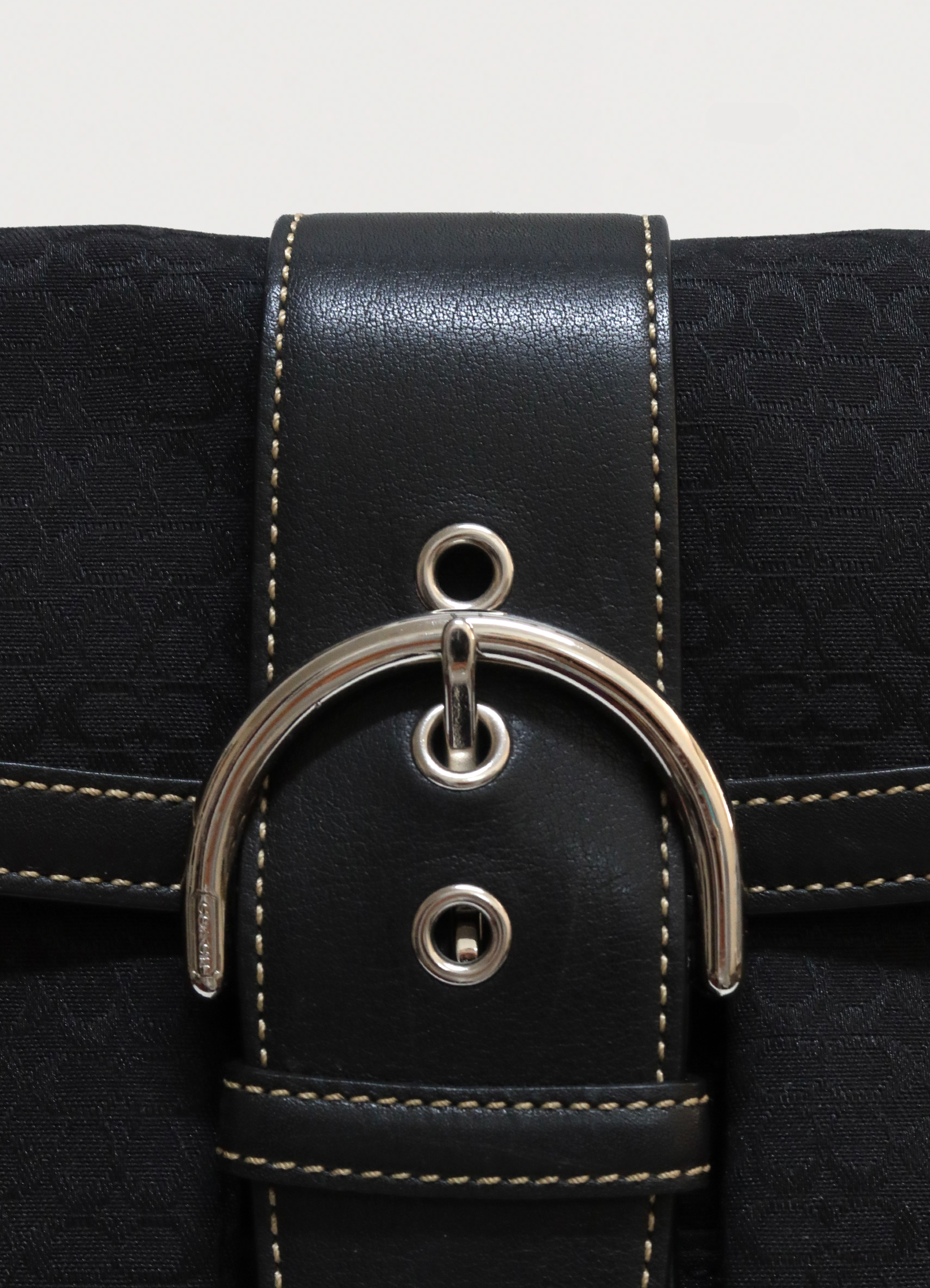 Detail shot of the silver-tone buckle and grommets on the front flap