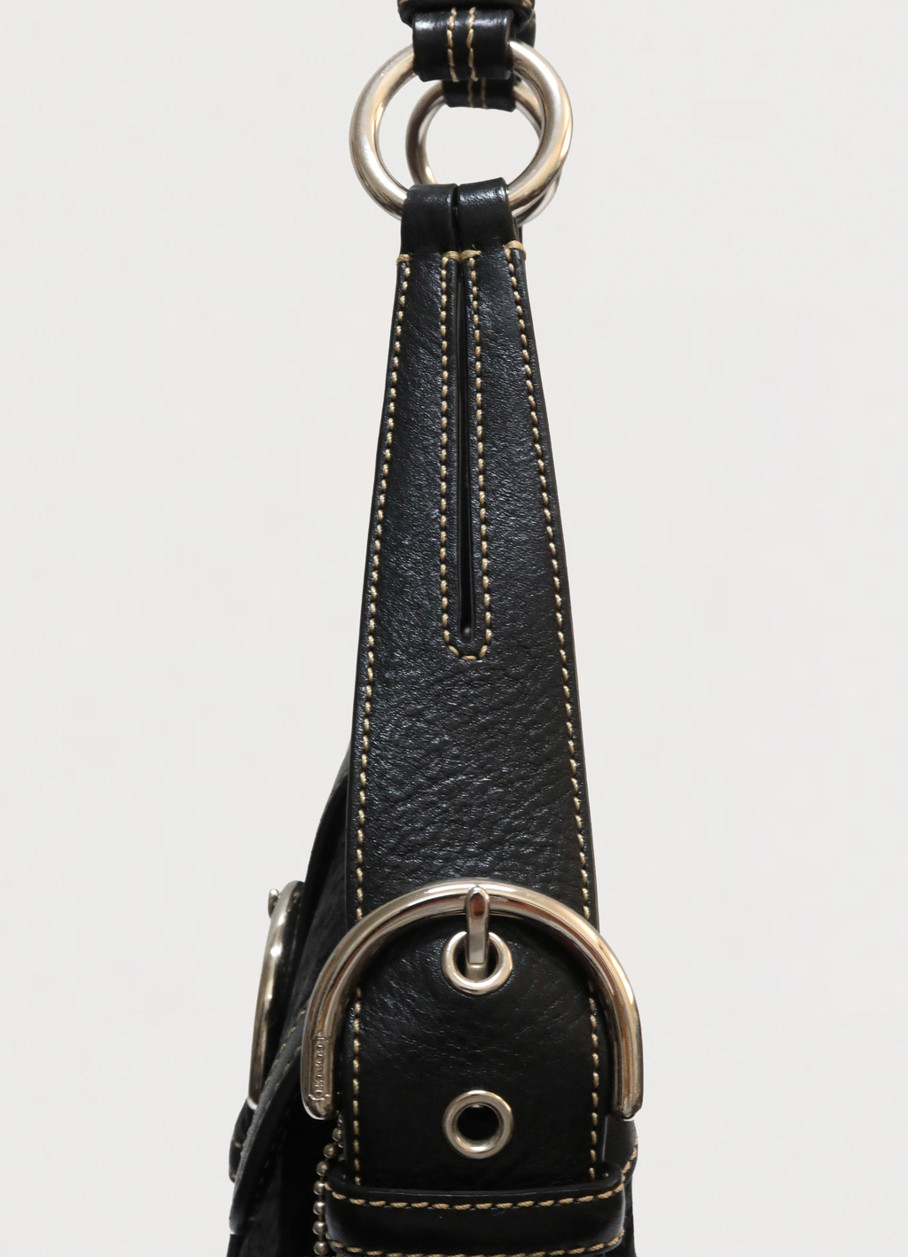 Detail of the black leather shoulder strap and O-ring attachment