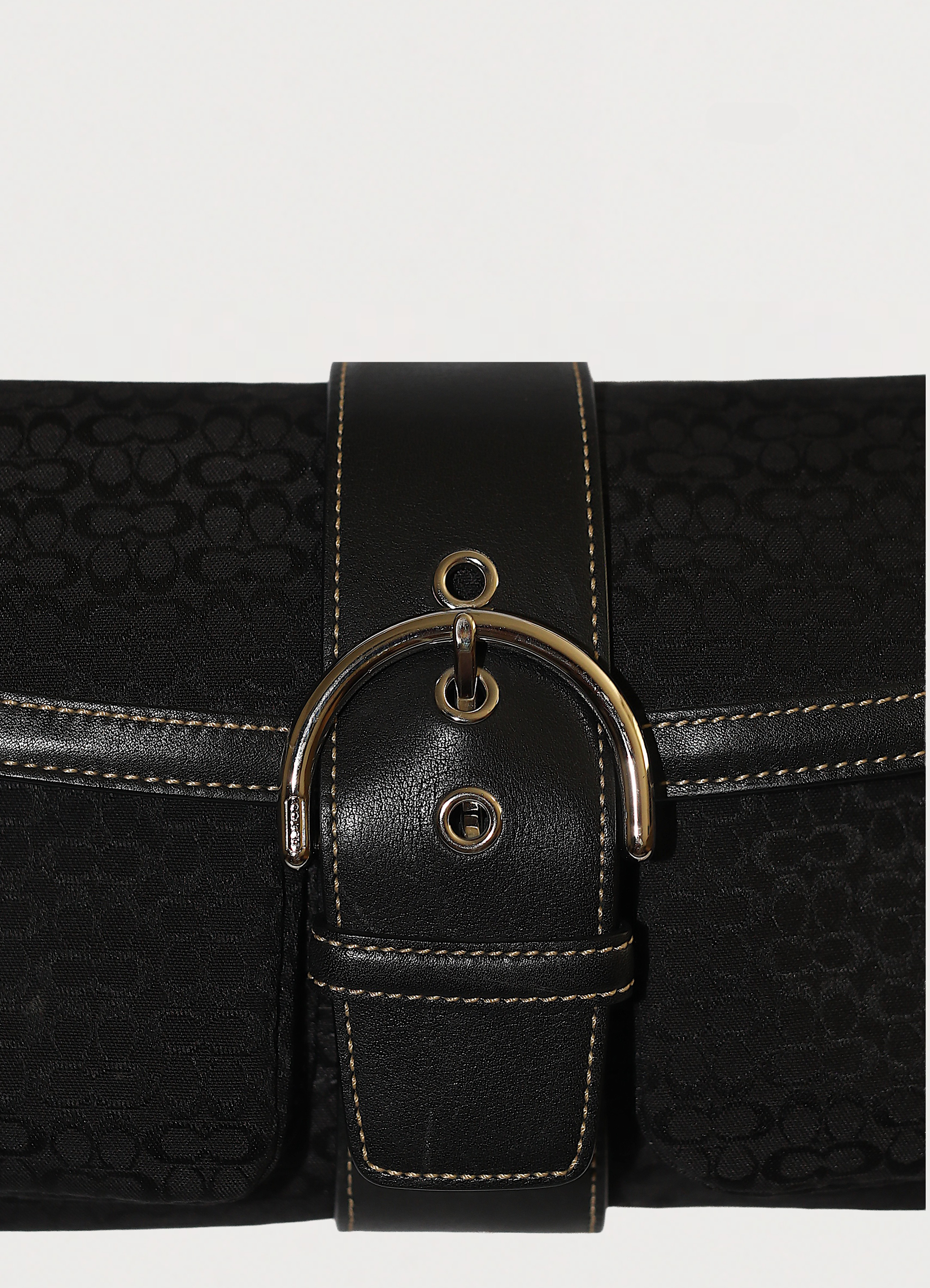 Macro shot of authentic black-on-black Coach signature jacquard canvas