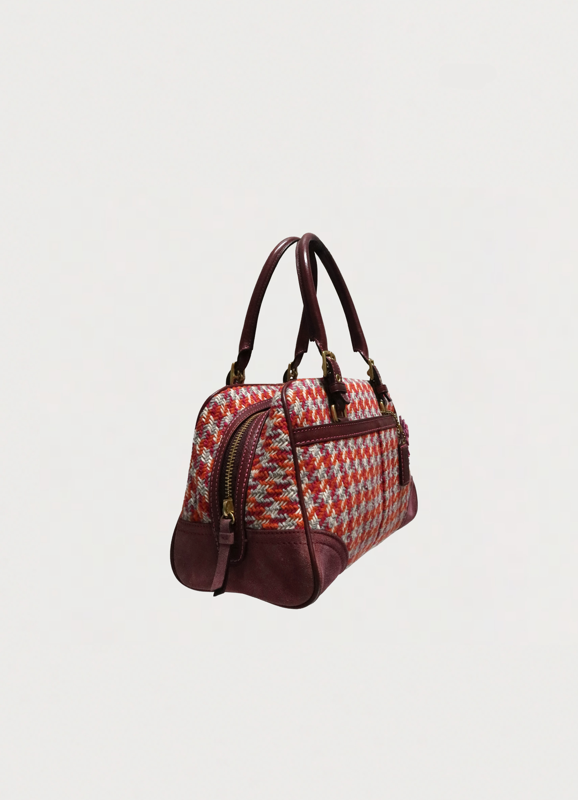 Angled view of Coach Hadley houndstooth satchel showing bag structure and suede corners