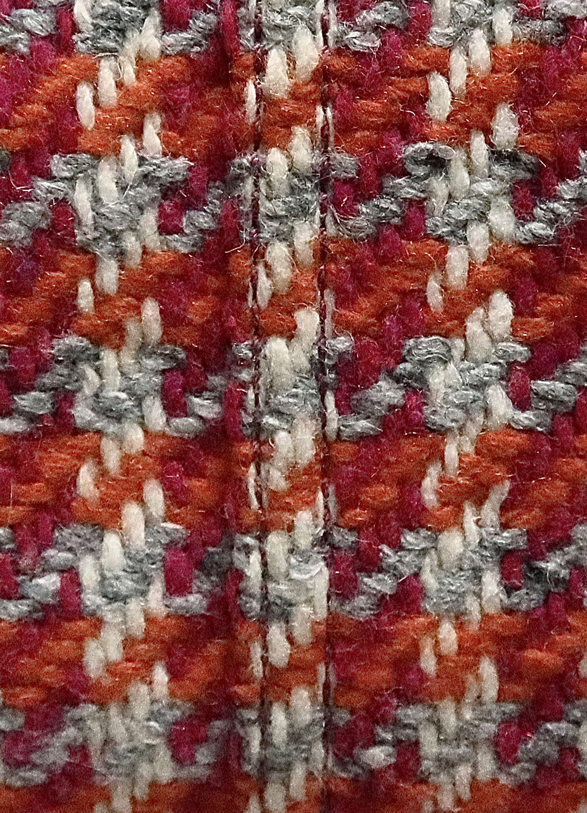 Macro shot of the orange and berry houndstooth wool tweed texture