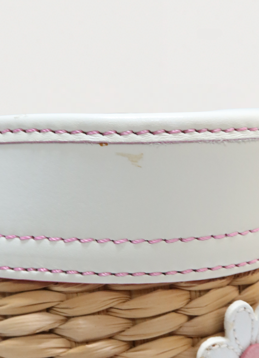 Detail shot of white leather top trim and pink contrast stitching